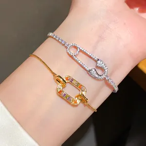 Close-up of 18K gold plated bracelets with zircon safety pin and colorful oval links