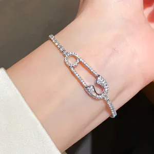 Close-up detail of a luxury 18K gold-plated safety pin bracelet with sparkling paved zircons.