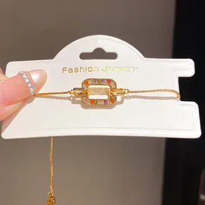 Close-up detail of 18K gold plated bracelet with colorful baguette zircon on white card