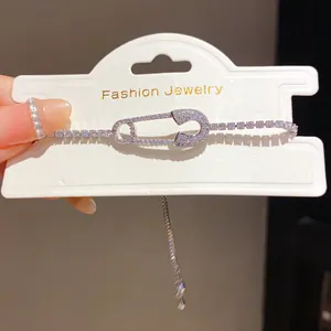 Close-up detail of silver-colored safety pin bracelet with sparkling cubic zirconia