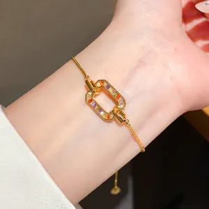 Detailed close-up of a gold-plated bracelet featuring multi-colored zircon stones on a wrist