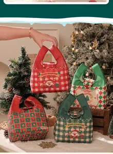 Vari sacchetti regalo di Natale in tela con stampe di Babbo Natale e auguri.