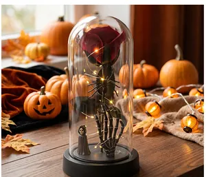 Detalle de la rosa roja de Halloween en cúpula con mano de esqueleto y luces LED