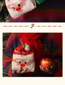 Detalle de una bolsa de regalo de Navidad de punto festiva con cara de Papá Noel