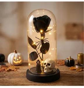 Detalle de rosa negra preservada de Halloween en cúpula de vidrio con calavera y LED