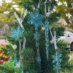 Dettaglio di fiocchi di neve e ghiaccioli in acrilico blu appesi a un albero di Natale