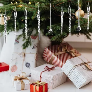 Dettaglio di decorazioni natalizie a forma di ghiacciolo trasparente appese all'albero