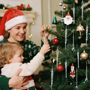 Madre e figlio decorano l'albero di Natale con ghiaccioli trasparenti e gocce ornamentali
