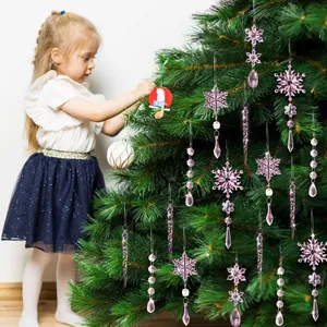 Fiocchi di neve e ghiaccioli in acrilico rosa appesi a un albero di Natale verde