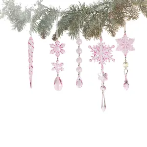 Set di ornamenti natalizi in acrilico rosa trasparente con fiocchi di neve e ghiaccioli.