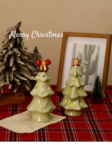 Detail of light green ceramic Christmas tree night lights on festive red tablecloth