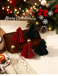 Detailopname van rode en groene geplooide papieren kerstboomornamenten met gouden bellen
