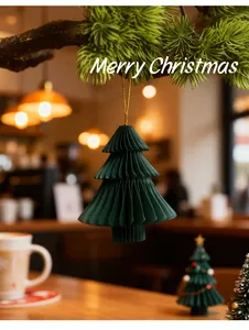 Detailweergave van een groene honingraat papieren kerstboomversiering hangend aan een tak
