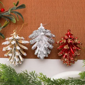 Detailweergave van gegalvaniseerde dennenappel kerstversiering in goud en rood.