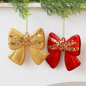 Primo piano di fiocchi decorativi natalizi rossi e oro con glitter