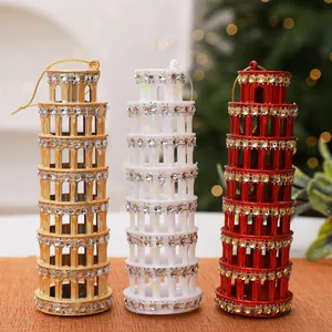 Vista detallada de tres adornos navideños de la Torre de Pisa decorados con pedrería