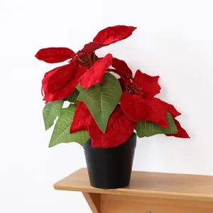 Détail d'un poinsettia artificiel rouge en pot noir pour la décoration de Noël.