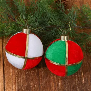 Detalle de bolas de Navidad de terciopelo rojo, blanco y verde con cintas doradas.