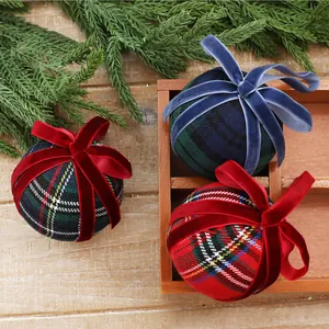 Detailed view of plaid Christmas ornament balls with elegant velvet bows and rustic accents
