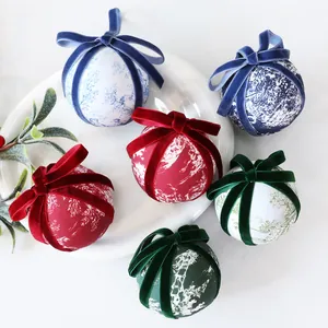 Close-up detail of patterned fabric Christmas ornaments featuring elegant velvet ribbon bows