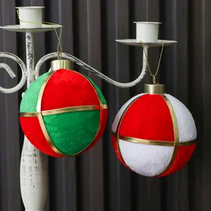 Detalle de bolas de Navidad de terciopelo rojo, verde y blanco con elegantes bandas doradas