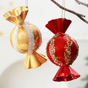 Detaillierte Aufnahme von goldfarbenen und roten Bonbon-Weihnachtskugeln mit Pailletten