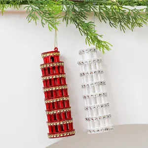 Vista detallada de adornos navideños de la Torre de Pisa rojos y blancos con strass.