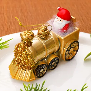 Close-up detail of golden Christmas train engine ornament featuring a mini Santa Claus