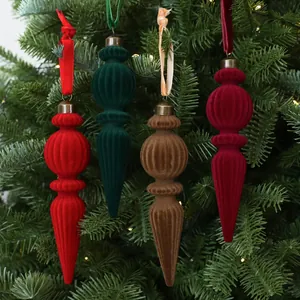 Detailansicht bunter beflockter Zapfen-Ornamente an einem grünen Weihnachtsbaum