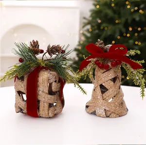 Détail de cloche de Noël et cadeau bambou avec nœuds velours rouge et pommes de pin.