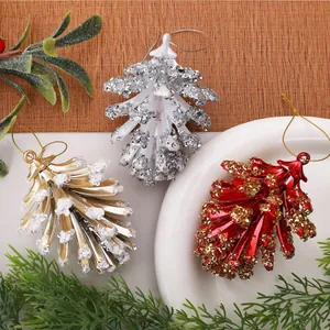 Detail van gegalvaniseerde rode, gouden en zilveren dennenappel kerstversieringen met glitter.