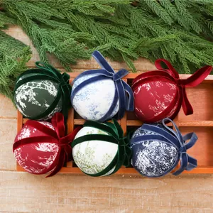 Assorted decorative cloth-wrapped Christmas balls featuring velvet ribbons and forest motifs