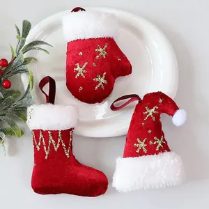 Een feestelijke set rood-witte pluche kerstversieringen met een kous, muts en een wantje.