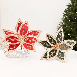 Détail de poinsettias artificiels rouges et verts avec motifs de feuilles brodés