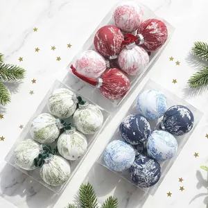 Detailed view of fabric-wrapped Christmas ball ornaments in festive gift boxes