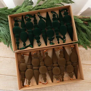 Detailansicht von grünen und braunen beflockten Samt-Weihnachtsschmuck in Geschenkboxen
