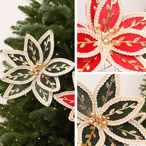 Détail rapproché de poinsettias de Noël en tissu rouge et vert avec broderie dorée.