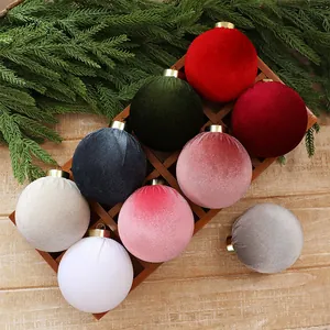 Detail of multicolor velvet Christmas ball ornaments with gold caps in a wooden tray