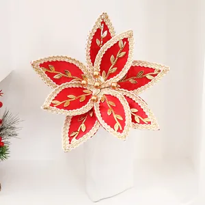 Détail d'une fleur de Noël artificielle rouge et or avec motifs brodés
