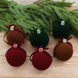 Detail of luxury velvet Christmas ornaments with rhinestones in burgundy, green, and brown.