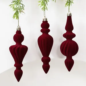 Detailopname van elegante bordeauxrode geflokte kerstballen met fluwelen afwerking.