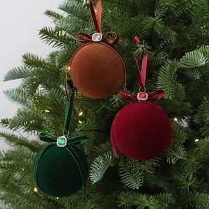 Close-up detail of velvet Christmas ball ornaments with rhinestones on a tree branch