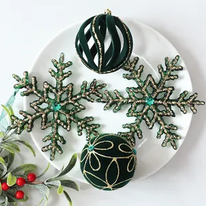 Detail view of green velvet Christmas balls and snowflake ornaments on a white plate