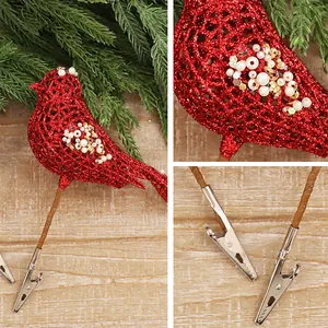 Makro-Detail von rotem Glitzer-Vogel-Ornament mit Clip für die Weihnachtsbaum-Dekoration.