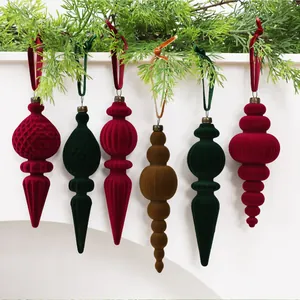Nahaufnahme von eleganten beflockten Samt-Weihnachtsschmuck an grünen Kiefernzweigen