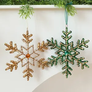 Close-up of festive snowflake ornaments with glitter finish hanging on a mantel shelf.