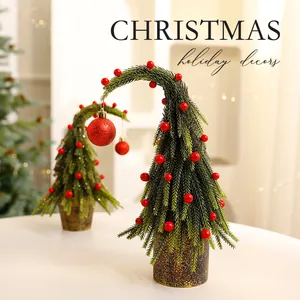 Unieke gebogen mini-kerstboom met rode ornamenten voor feestelijke tafeldecoratie
