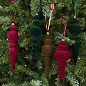 Detailansicht von beflockten Samt-Weihnachtslaternenanhängern an einer grünen Tanne