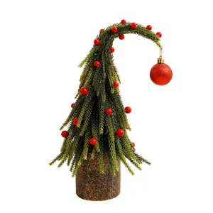 Unieke gebogen kerstboom tafeldecoratie met rode bessen en glitterende bal