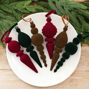 Elegantes Set aus Samt-Weihnachtsschmuck mit beflockten Laternen- und Zapfenformen.